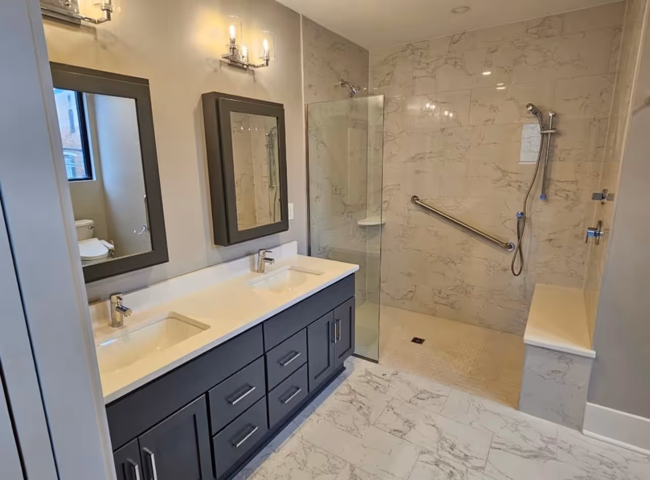 A remodeled bathroom with a double vanity and a walk-in shower