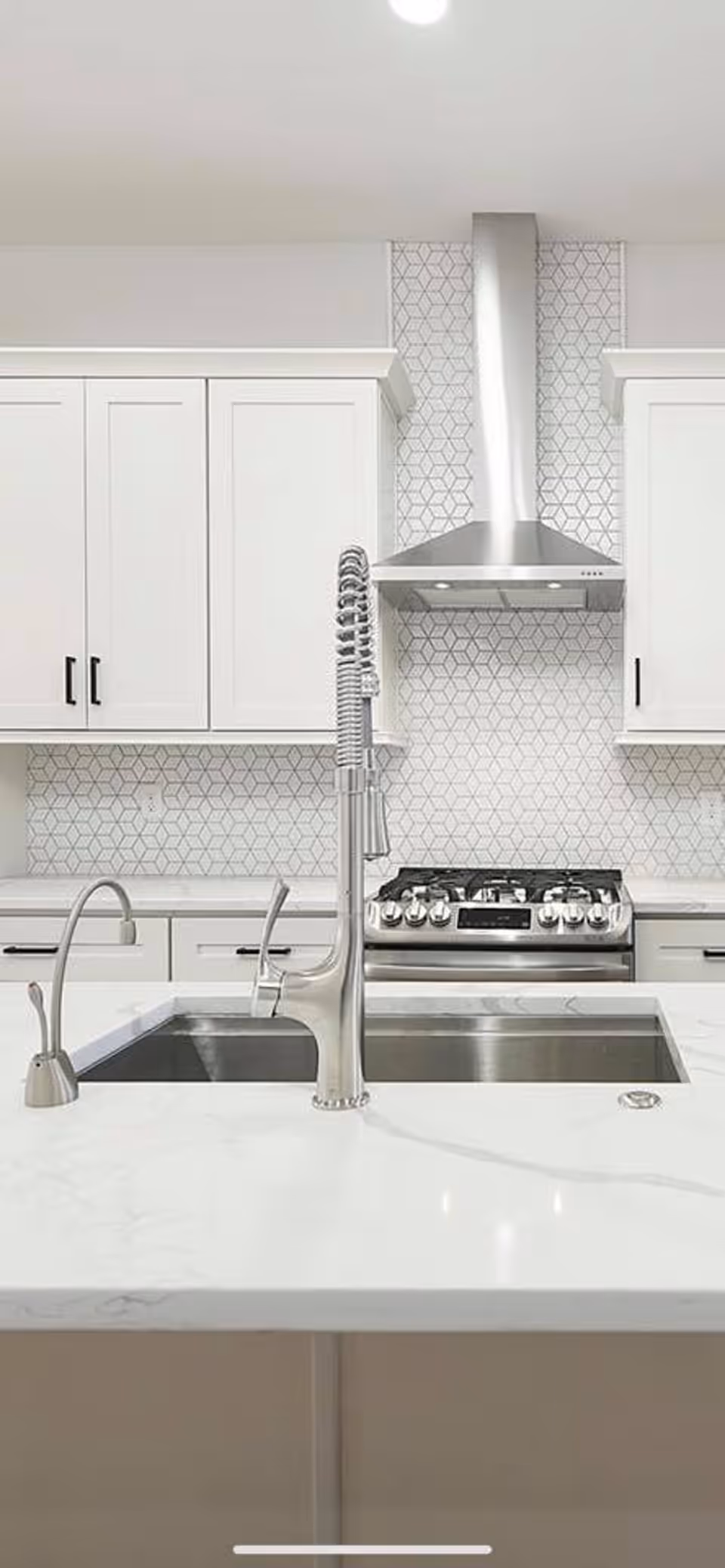 A remodeled kitchen with a pull-down faucet, undermount sink and gas range